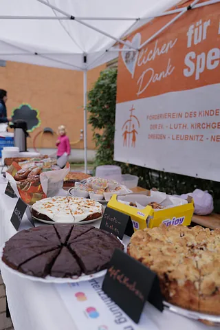 Eine Tafel mit Kuchen. Im Hintergrund ist der Banner des Vereins zu sehen.